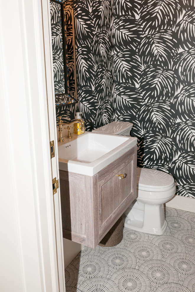 Inspiration for a small traditional cloakroom in New York with recessed-panel cabinets, beige cabinets, a two-piece toilet, multi-coloured walls, mosaic tile flooring, a submerged sink and grey floors.