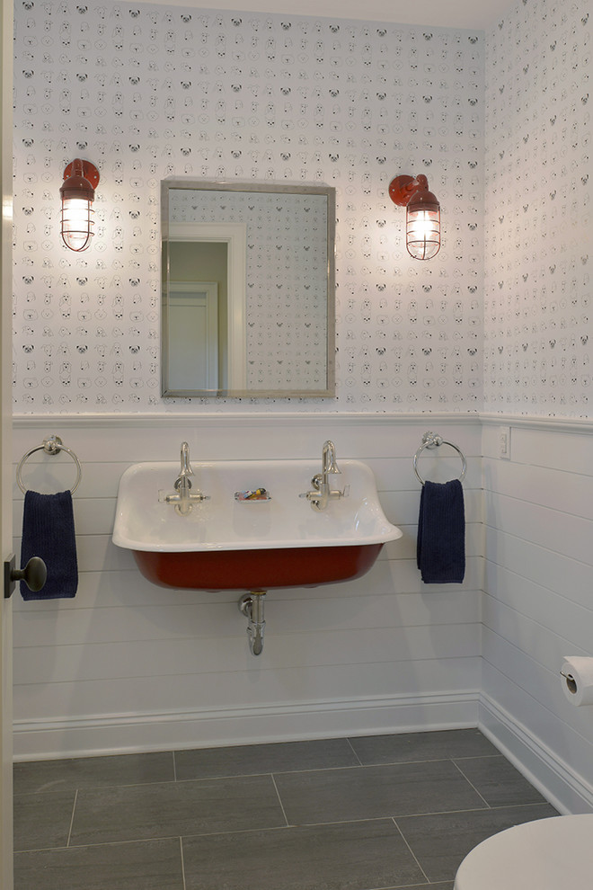 Modelo de aseo minimalista con lavabo suspendido, sanitario de una pieza, paredes blancas y suelo de baldosas de porcelana