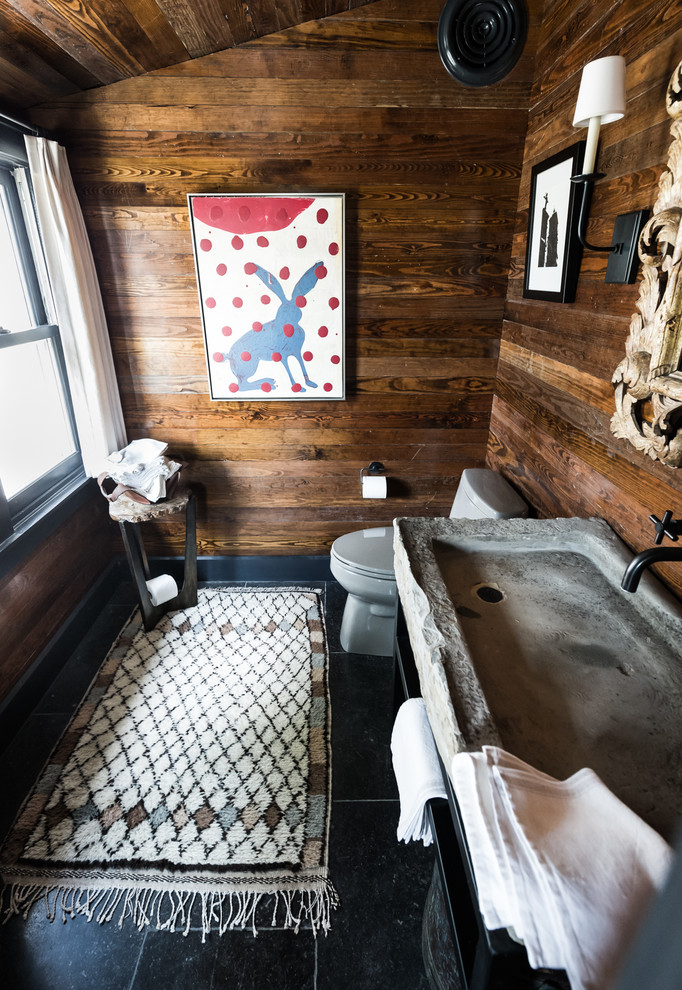 Inspiration for a small rustic slate floor and black floor powder room remodel in Dallas with a trough sink, limestone countertops, gray countertops, open cabinets, black cabinets, a two-piece toilet and brown walls