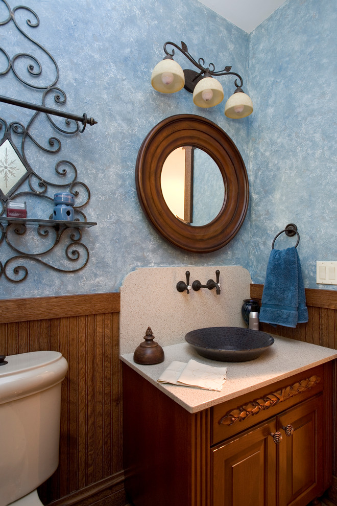 Ispirazione per un grande bagno di servizio chic con consolle stile comò, ante in legno scuro, WC a due pezzi, pareti blu, lavabo a bacinella e top in pietra calcarea