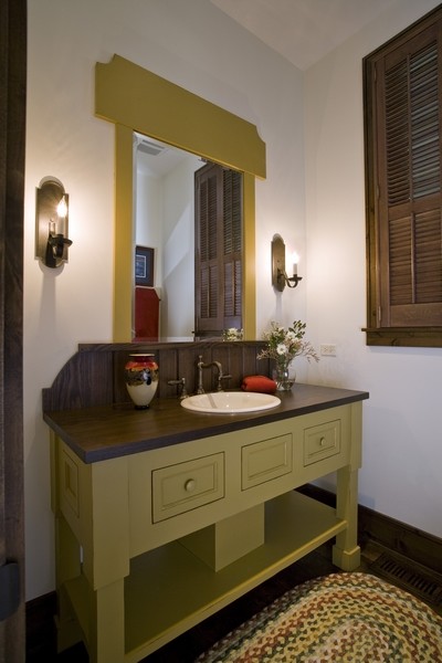 Idéer för mycket stora vintage toaletter, med möbel-liknande, vita väggar, mörkt trägolv, ett nedsänkt handfat, träbänkskiva och gröna skåp