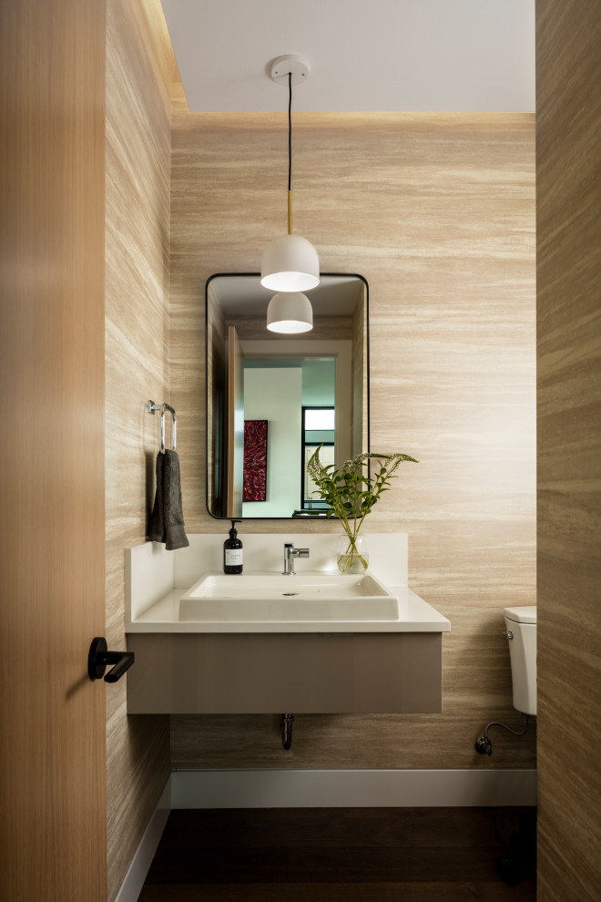 Foto di un bagno di servizio design con ante lisce, ante grigie, pareti beige, parquet scuro, lavabo a bacinella, pavimento marrone e top bianco