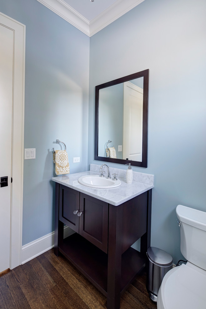 Diseño de aseo clásico renovado con lavabo encastrado, armarios tipo mueble, puertas de armario de madera en tonos medios, encimera de granito y sanitario de dos piezas