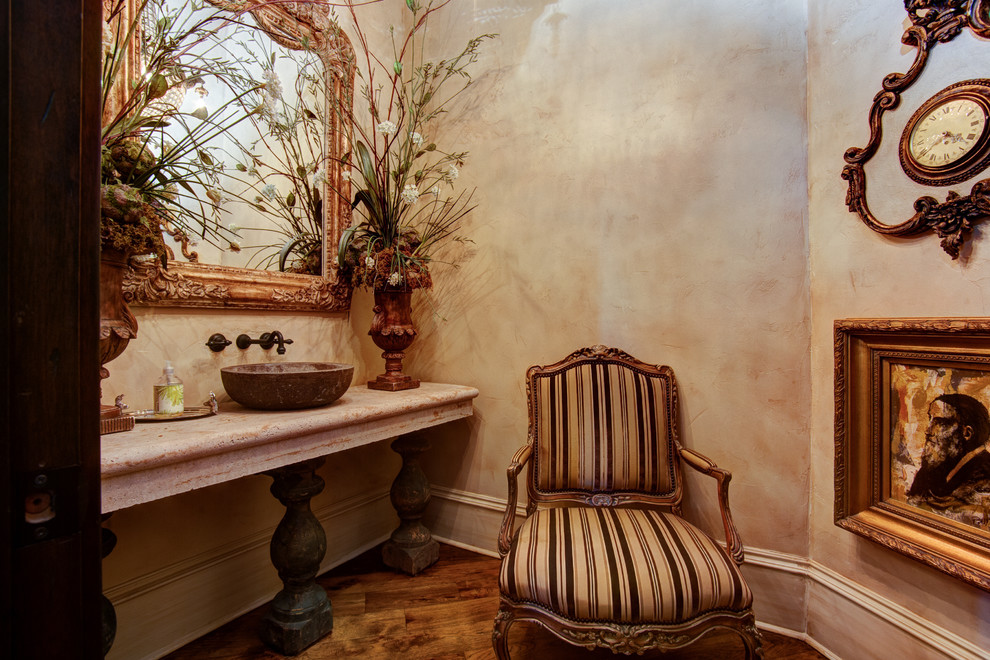 Пример оригинального дизайна: туалет среднего размера в классическом стиле с раздельным унитазом, бежевой плиткой, каменной плиткой, бежевыми стенами, темным паркетным полом, настольной раковиной, столешницей из дерева и коричневым полом