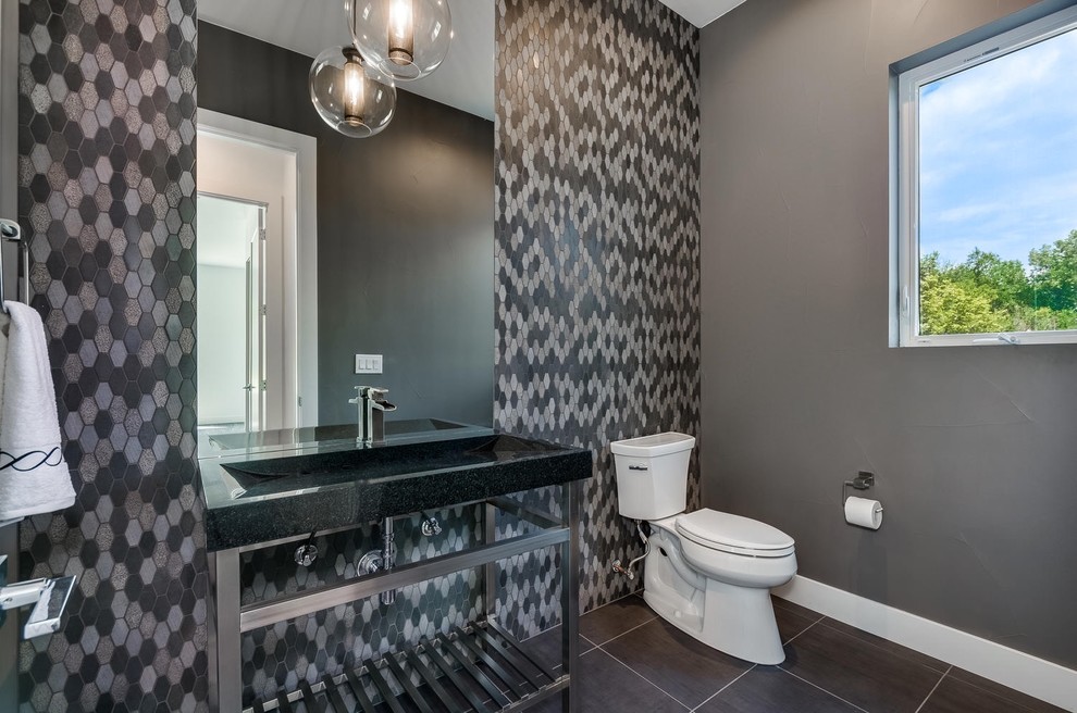 Photo of a medium sized contemporary cloakroom in Denver with multi-coloured tiles, stone tiles, grey walls, porcelain flooring, a trough sink and grey floors.