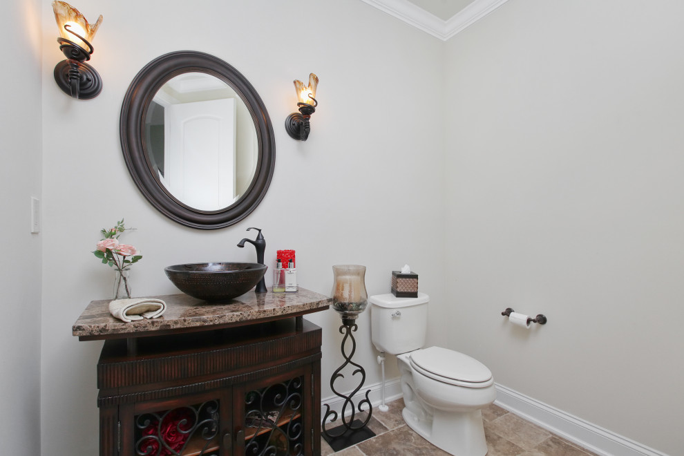 Example of a mid-sized classic porcelain tile and brown floor powder room design in Philadelphia with furniture-like cabinets, medium tone wood cabinets, a two-piece toilet, gray walls, a vessel sink, brown countertops and a built-in vanity