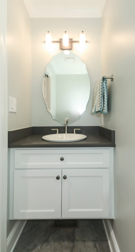 This is an example of a small classic cloakroom in Atlanta with shaker cabinets, white cabinets, a two-piece toilet, grey walls, porcelain flooring, a built-in sink, engineered stone worktops, grey floors, black worktops and a floating vanity unit.