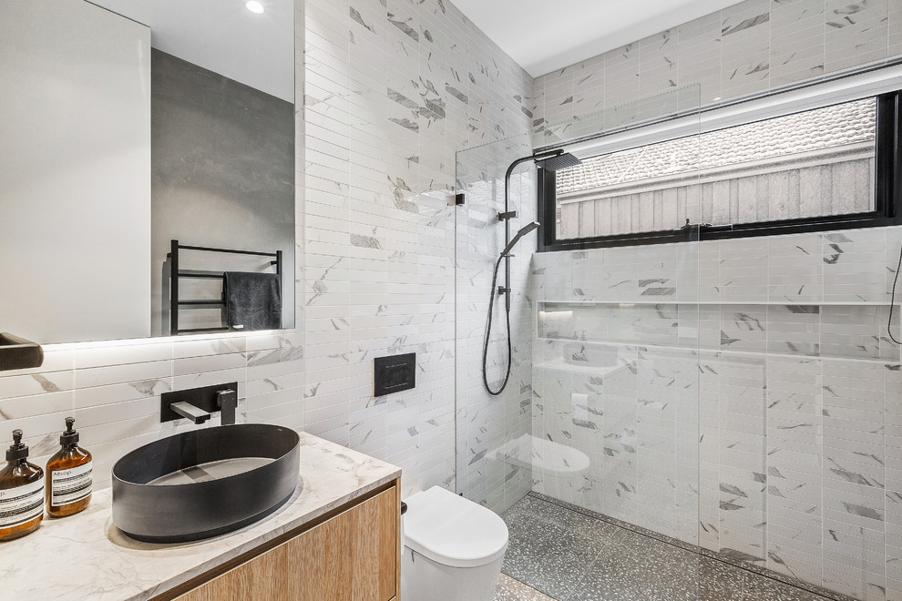 Inspiration för ett mellanstort funkis grå grått badrum, med skåp i ljust trä, en vägghängd toalettstol, vit kakel, mosaik, vita väggar, klinkergolv i porslin, ett fristående handfat, marmorbänkskiva och grått golv