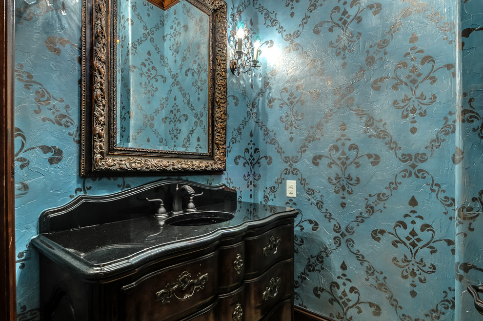 Mediterrane Gästetoilette mit integriertem Waschbecken, dunklen Holzschränken, Granit-Waschbecken/Waschtisch und blauer Wandfarbe in Dallas