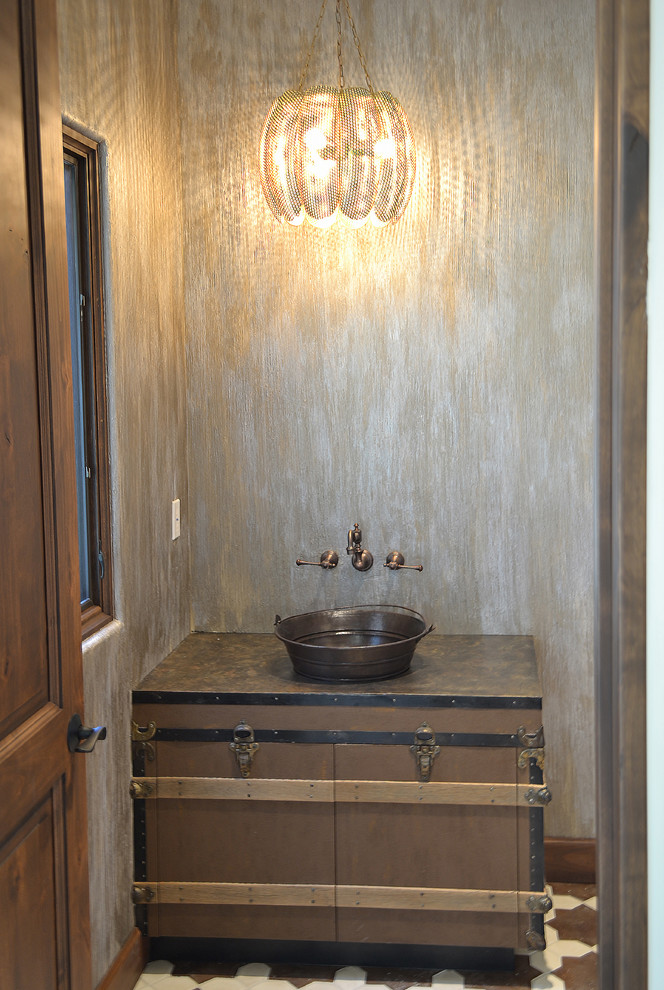 This is an example of a medium sized rustic cloakroom in Phoenix with medium wood cabinets, beige walls, cement flooring, a vessel sink and multi-coloured floors.