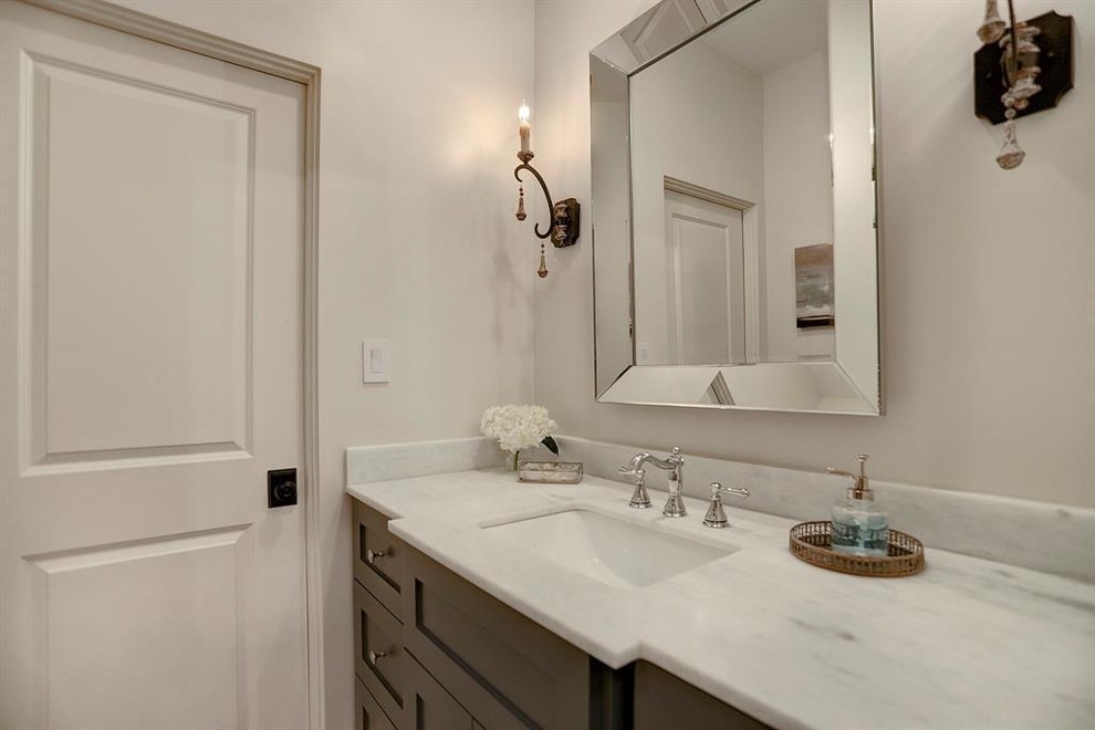 Cette image montre un petit WC et toilettes traditionnel en bois foncé avec un placard à porte shaker, WC séparés, un sol en travertin, un lavabo encastré, un plan de toilette en quartz modifié, un sol gris, un plan de toilette blanc et un mur beige.