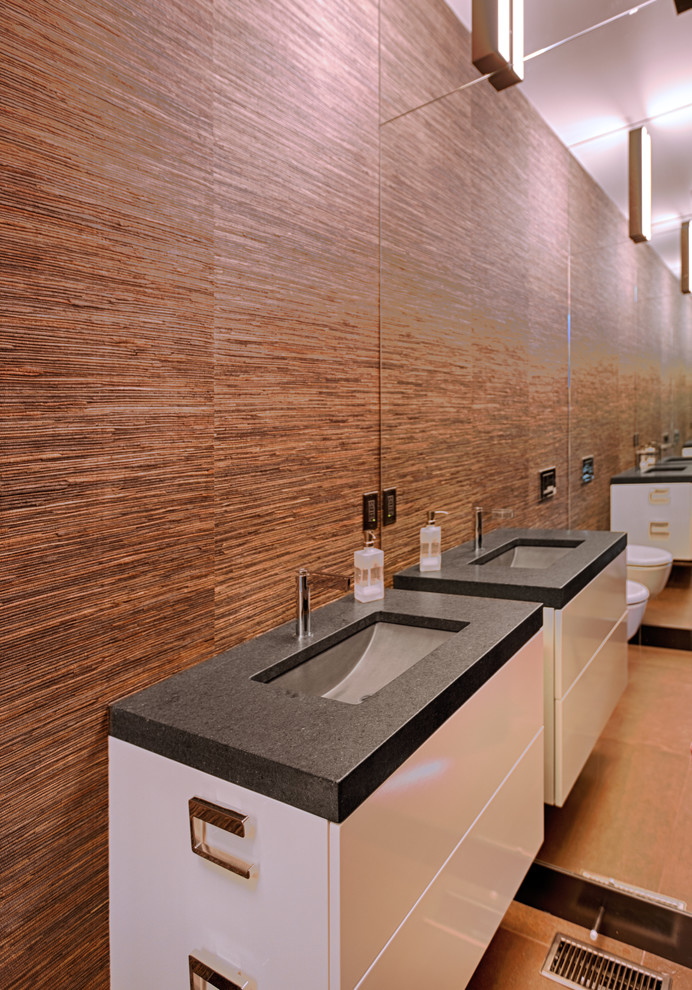 Foto di un bagno di servizio moderno di medie dimensioni con ante lisce, ante bianche, WC sospeso, pareti marroni, pavimento in gres porcellanato, lavabo sottopiano, top in granito e pavimento marrone