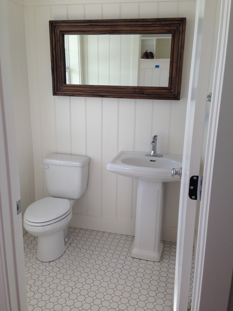 Ejemplo de aseo de estilo de casa de campo pequeño con lavabo con pedestal y paredes blancas