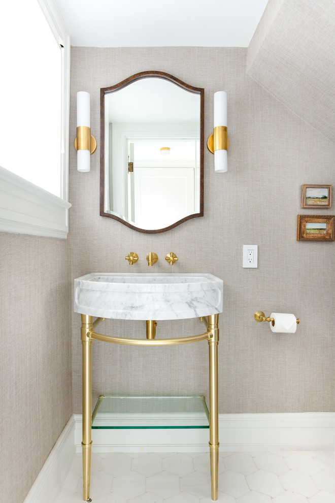 Klassisk inredning av ett litet toalett, med beige väggar, marmorgolv, vitt golv och ett konsol handfat