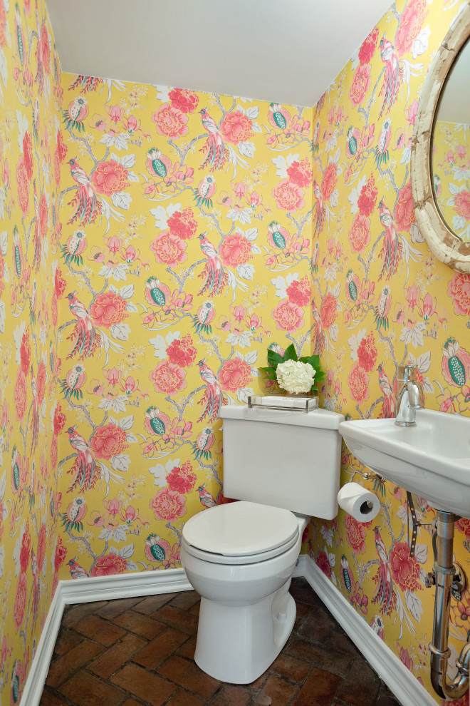 Example of a small brick floor and red floor powder room design in Dallas with a two-piece toilet, yellow walls and a wall-mount sink