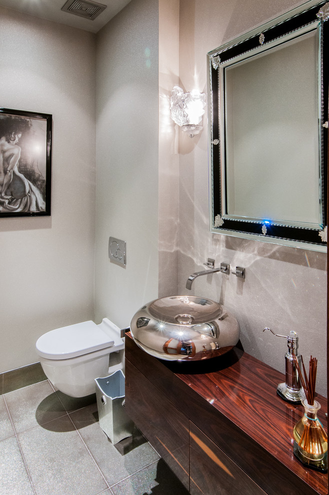 Esempio di un bagno di servizio design con lavabo a bacinella, WC sospeso, ante lisce, ante in legno scuro, top in legno e top marrone