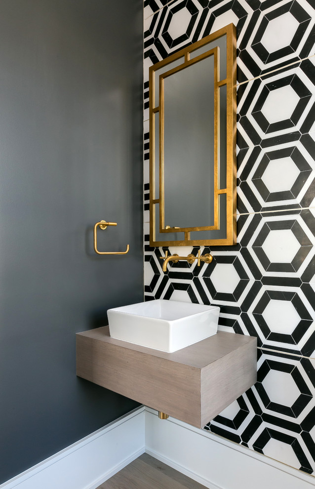 На фото: туалет в современном стиле с разноцветными стенами, настольной раковиной, столешницей из дерева, черно-белой плиткой и разноцветной плиткой