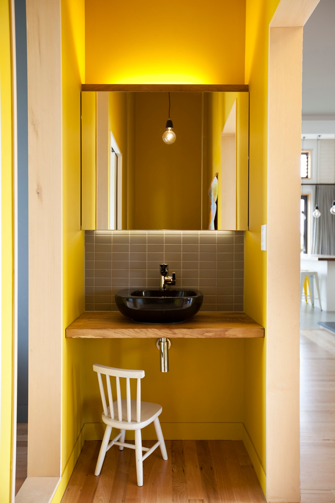 Inspiration för små moderna brunt toaletter, med ett fristående handfat, träbänkskiva, grå kakel och stenkakel