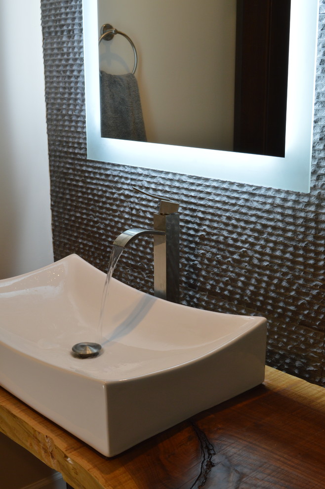 Immagine di un piccolo bagno di servizio bohémian con lavabo a bacinella, top in legno, piastrelle grigie e pareti grigie