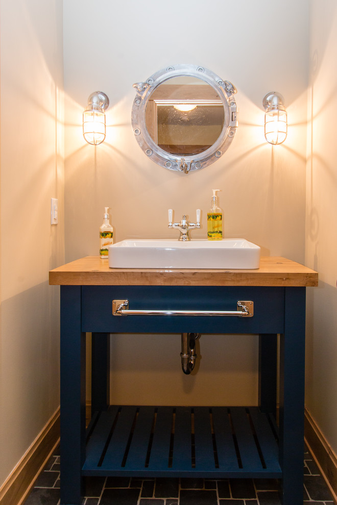 Immagine di un piccolo bagno di servizio country con ante blu, pareti bianche, pavimento in legno massello medio, lavabo da incasso e top in legno