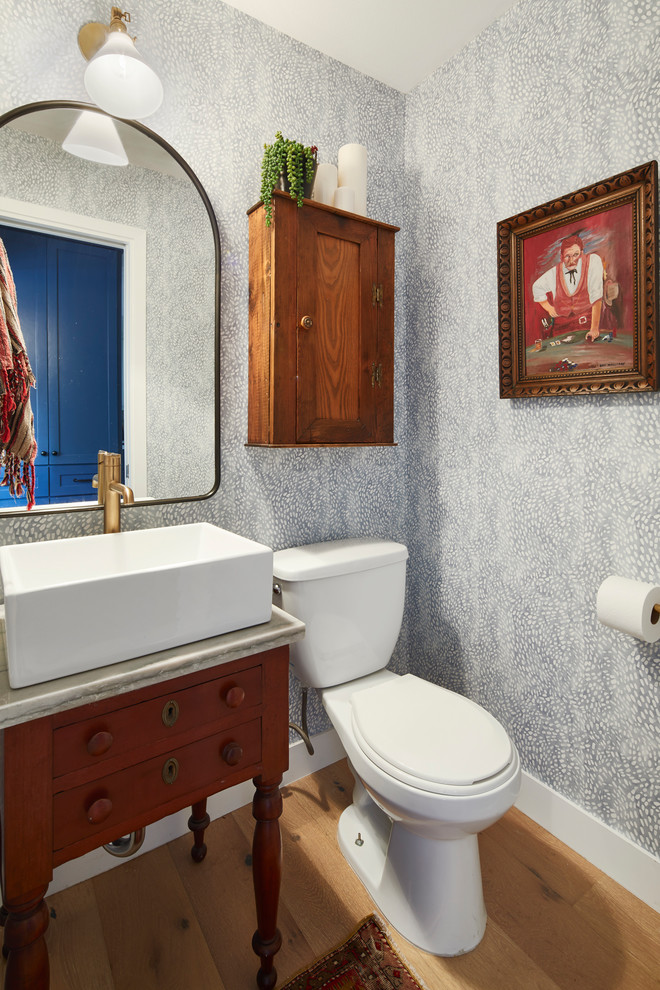 Foto di un bagno di servizio chic con consolle stile comò, ante in legno scuro, parquet chiaro, lavabo a bacinella e top in marmo