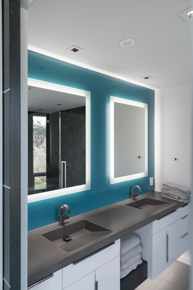 Immagine di un bagno di servizio design di medie dimensioni con ante lisce, ante bianche, piastrelle blu, pareti blu, pavimento in ardesia, lavabo integrato, top in quarzo composito e pavimento grigio