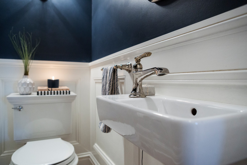 Immagine di un piccolo bagno di servizio classico con WC a due pezzi, pareti blu, pavimento in legno massello medio, lavabo sospeso e pavimento marrone