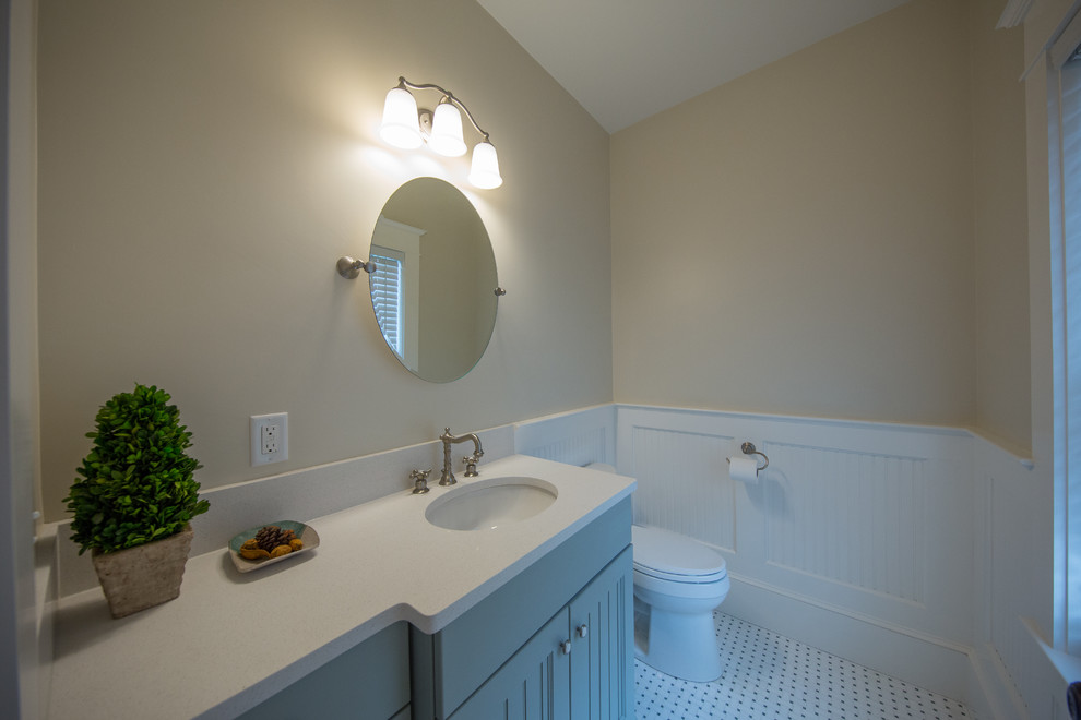 Photo of a small coastal cloakroom in Boston with a two-piece toilet, beige walls, porcelain flooring, a submerged sink, engineered stone worktops, white floors and white worktops.