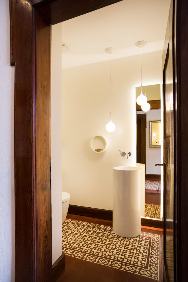 Cette image montre un WC et toilettes traditionnel de taille moyenne avec un carrelage marron, un carrelage multicolore, un mur blanc, un lavabo de ferme, un sol en carrelage de terre cuite et un sol multicolore.
