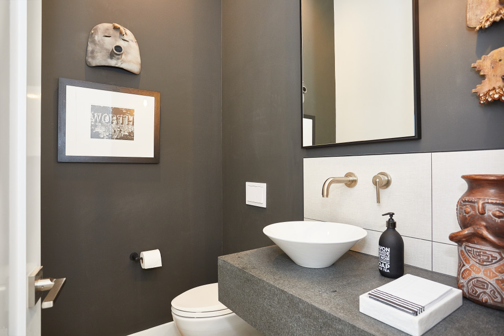Foto di un bagno di servizio minimal di medie dimensioni con ante lisce, WC sospeso, piastrelle grigie, piastrelle in gres porcellanato, pareti grigie, lavabo a bacinella, top in cemento e top grigio