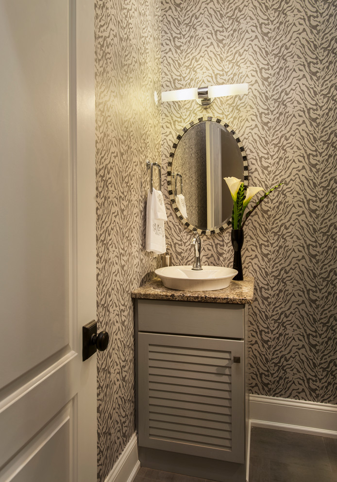 Cette image montre un petit WC et toilettes design avec un placard à porte persienne, des portes de placard blanches, un mur multicolore, parquet foncé, une vasque et un plan de toilette gris.