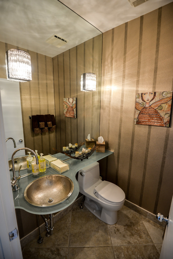 Пример оригинального дизайна: туалет в современном стиле с накладной раковиной, стеклянной столешницей, унитазом-моноблоком и бежевой плиткой