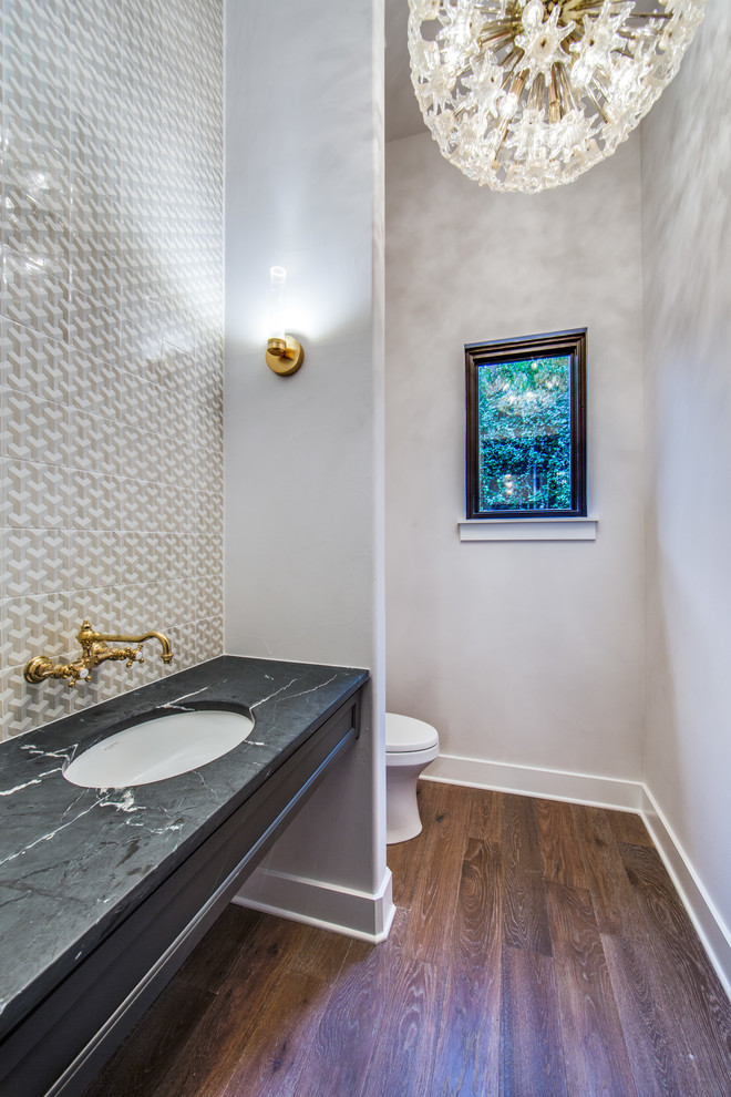 Photo of a medium sized traditional cloakroom in Dallas with freestanding cabinets, grey cabinets, multi-coloured tiles, ceramic tiles, grey walls, light hardwood flooring, a submerged sink, soapstone worktops, brown floors and a one-piece toilet.