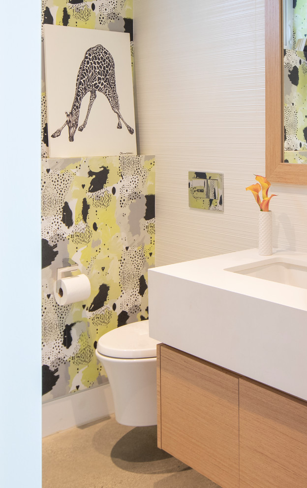 Cette image montre un petit WC suspendu minimaliste en bois clair avec un placard à porte plane, un carrelage multicolore, des carreaux de céramique, un mur multicolore, sol en béton ciré, un lavabo encastré, un plan de toilette en quartz modifié, un sol gris et un plan de toilette blanc.