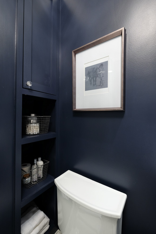 Idée de décoration pour un WC et toilettes tradition de taille moyenne avec un placard sans porte, des portes de placard bleues, WC séparés, un mur bleu et un sol en carrelage de porcelaine.