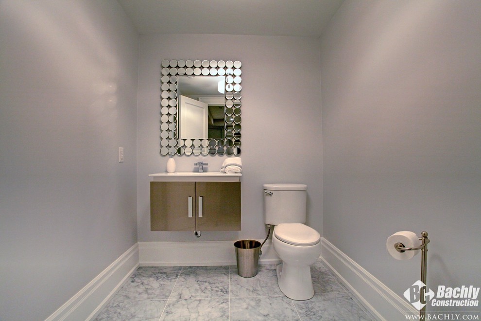 Cette photo montre un WC et toilettes chic en bois foncé de taille moyenne avec un lavabo suspendu, un placard à porte plane, WC à poser et un mur gris.