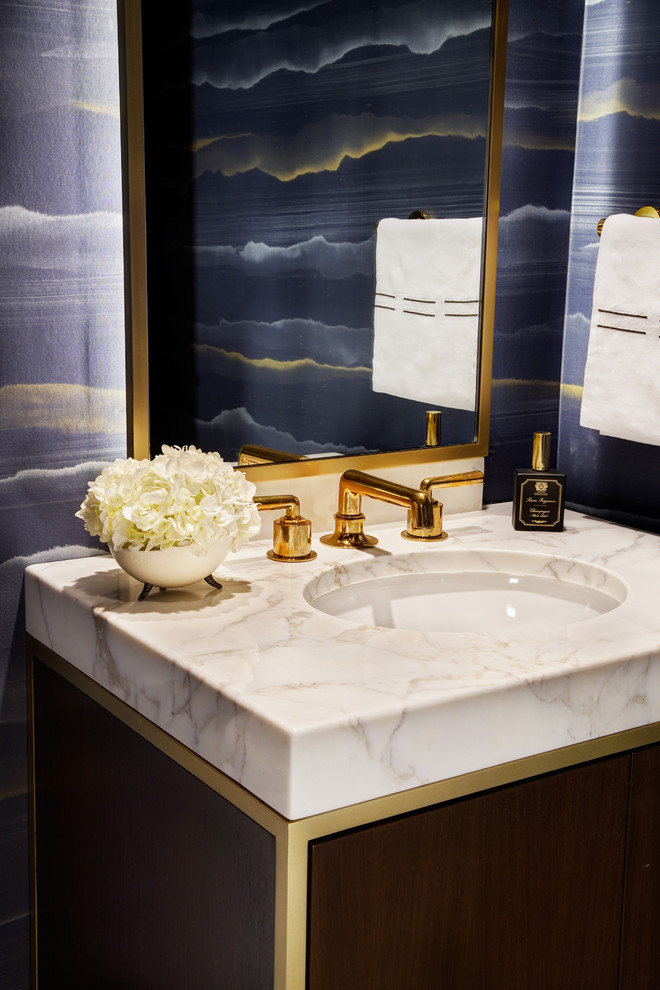 Example of a small trendy beige tile limestone floor and beige floor powder room design in Chicago with flat-panel cabinets, dark wood cabinets, a one-piece toilet, blue walls, an undermount sink and marble countertops
