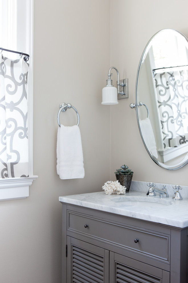 Foto di un piccolo bagno di servizio chic con ante a persiana, ante marroni, pareti beige, lavabo sottopiano, top in marmo e top bianco
