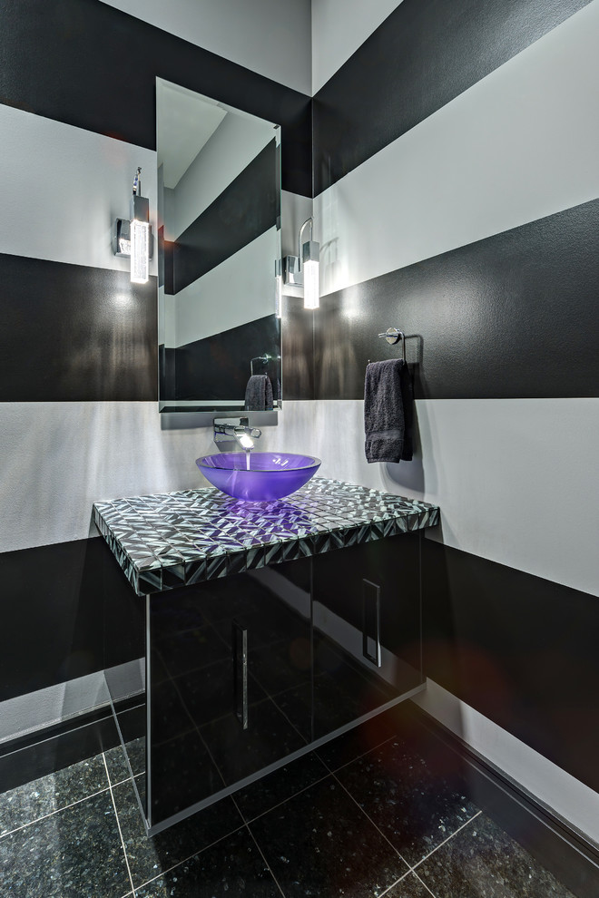 Imagen de aseo contemporáneo con lavabo sobreencimera, armarios con paneles lisos y puertas de armario negras