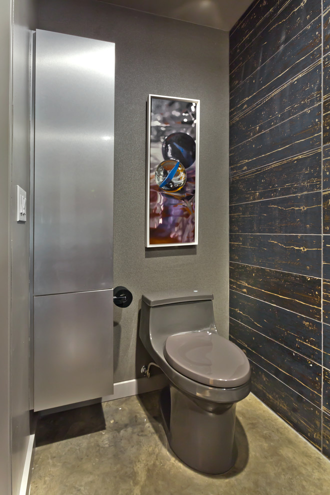 Kleine Moderne Gästetoilette mit flächenbündigen Schrankfronten, schwarzen Schränken, Toilette mit Aufsatzspülkasten, schwarzen Fliesen, Porzellanfliesen, grauer Wandfarbe, Betonboden, Aufsatzwaschbecken und Granit-Waschbecken/Waschtisch in Minneapolis