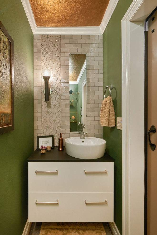 Cette photo montre un petit WC et toilettes éclectique avec un placard à porte plane, des portes de placard blanches, un carrelage vert, des carreaux de céramique, un mur vert, un plan de toilette en granite, un plan de toilette noir et meuble-lavabo suspendu.