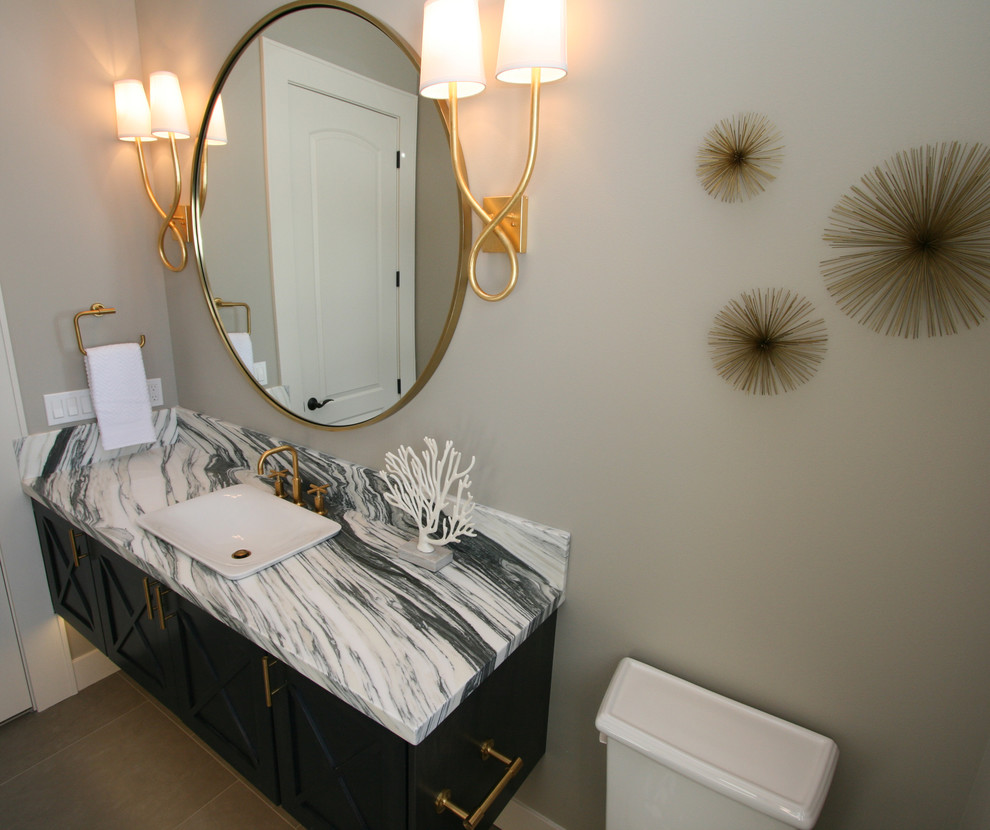 Example of a large transitional gray tile and porcelain tile porcelain tile powder room design in Seattle with furniture-like cabinets, black cabinets, a two-piece toilet, gray walls, a vessel sink and marble countertops