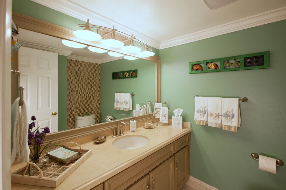 Exempel på ett maritimt toalett, med ett undermonterad handfat, luckor med upphöjd panel, beige skåp, granitbänkskiva, glaskakel och gröna väggar