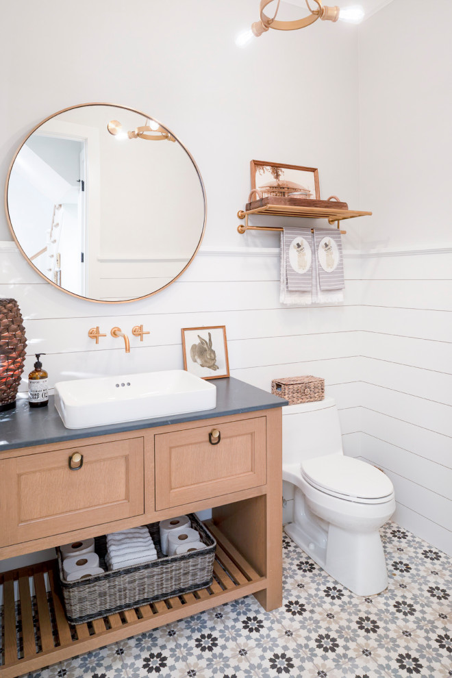 This is an example of a medium sized traditional cloakroom in Minneapolis with open cabinets, medium wood cabinets, a two-piece toilet, grey walls, mosaic tile flooring, a vessel sink, multi-coloured floors and grey worktops.