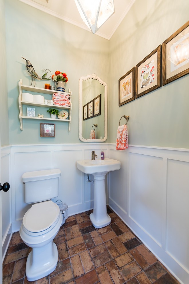 ジャクソンビルにある高級な広いカントリー風のおしゃれなトイレ・洗面所 (分離型トイレ、緑の壁、レンガの床、ペデスタルシンク、マルチカラーの床) の写真