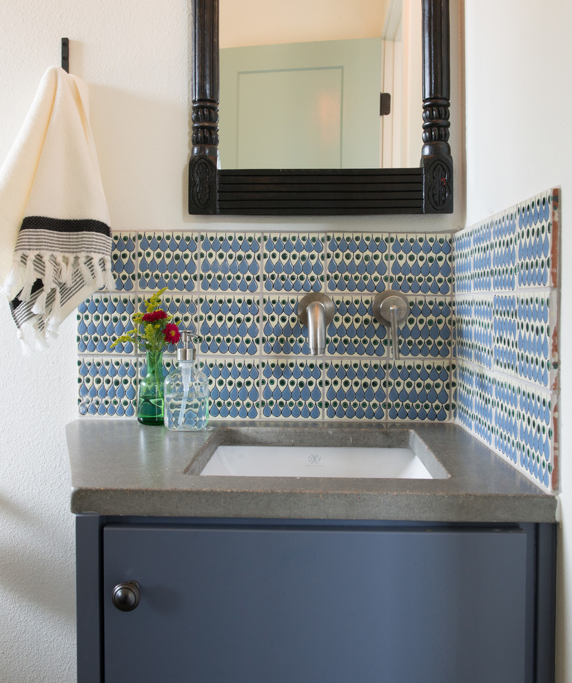 オースティンにある高級な小さなカントリー風のおしゃれなトイレ・洗面所 (フラットパネル扉のキャビネット、青いキャビネット、青いタイル、セラミックタイル、白い壁、アンダーカウンター洗面器、コンクリートの洗面台、グレーの洗面カウンター) の写真