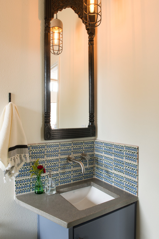 Immagine di un piccolo bagno di servizio country con ante lisce, ante blu, piastrelle blu, piastrelle in ceramica, pareti bianche, lavabo sottopiano, top in cemento e top grigio