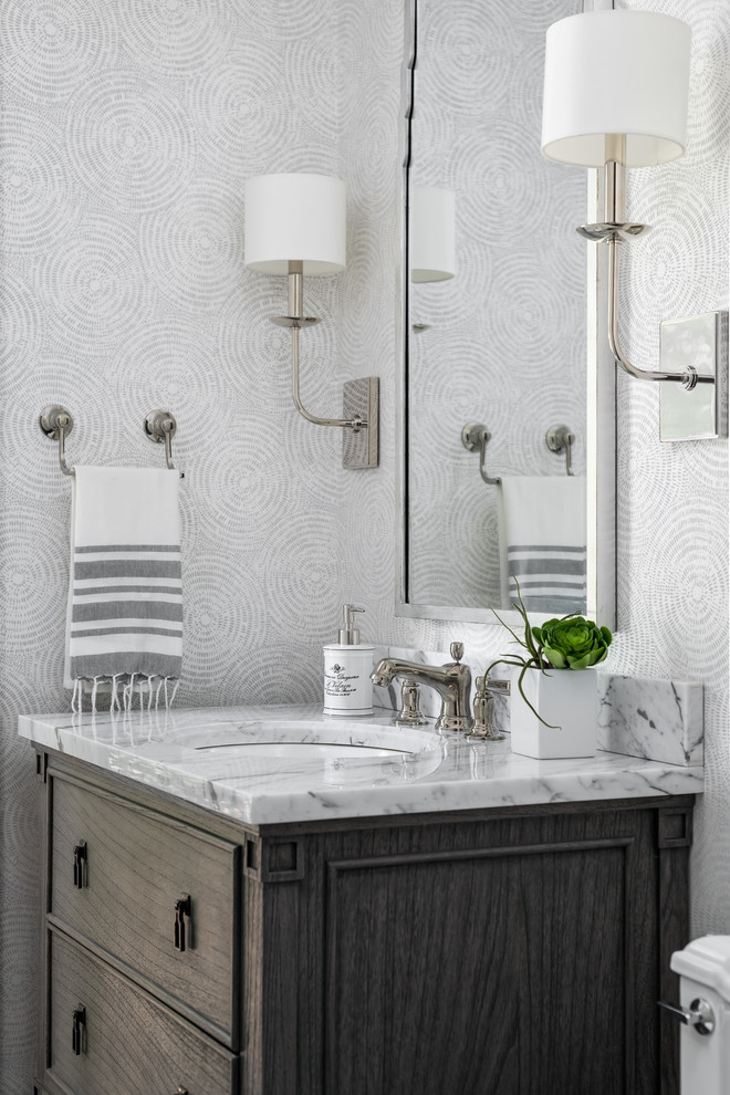 Klassische Gästetoilette mit Marmor-Waschbecken/Waschtisch, weißer Waschtischplatte, bunten Wänden, Unterbauwaschbecken und dunklen Holzschränken in Chicago