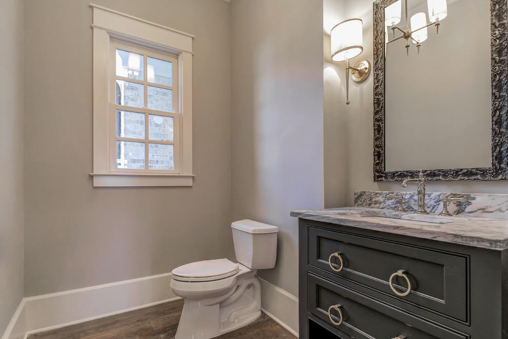 Inspiration for a medium sized classic cloakroom in Atlanta with grey cabinets, grey walls, medium hardwood flooring, a built-in sink, marble worktops, a two-piece toilet and recessed-panel cabinets.
