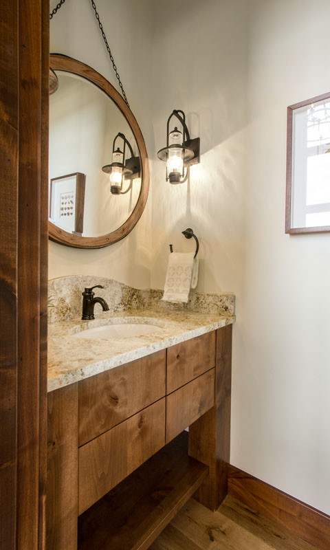 Réalisation d'un grand WC et toilettes chalet en bois brun avec un placard à porte plane, un mur beige, parquet clair, un lavabo encastré et un plan de toilette en granite.